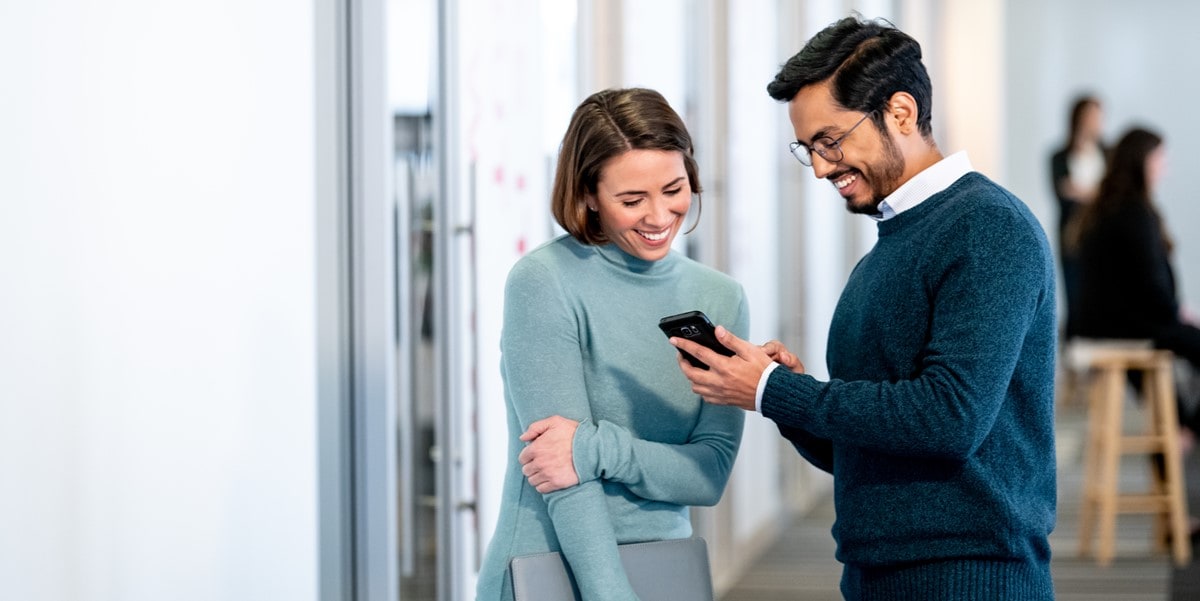 man and woman looking at phone