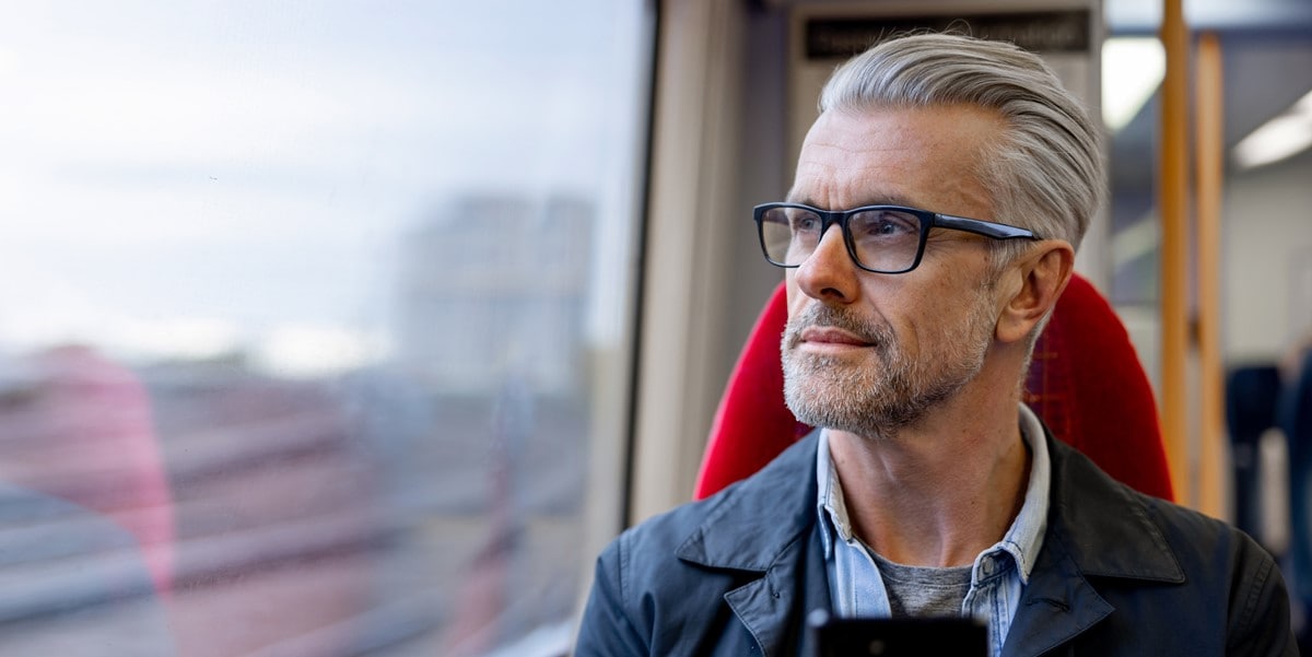 man looking out train window
