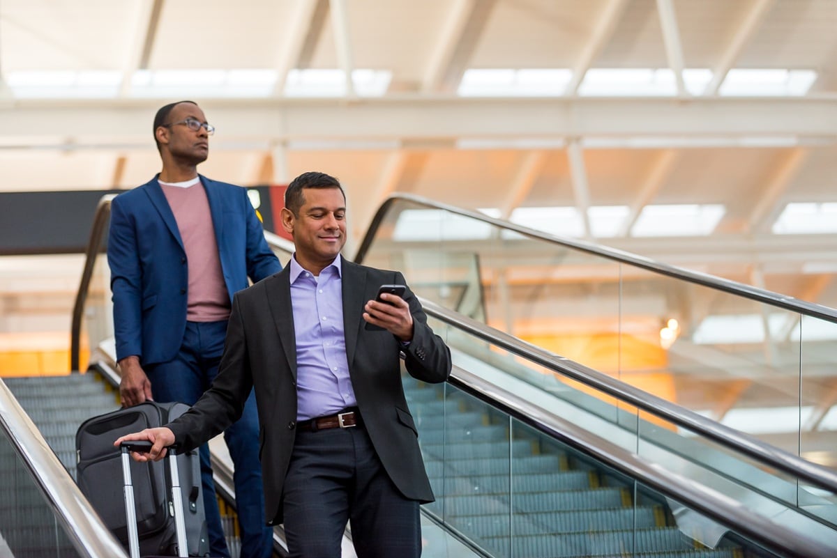 Two men on escalator at airport 