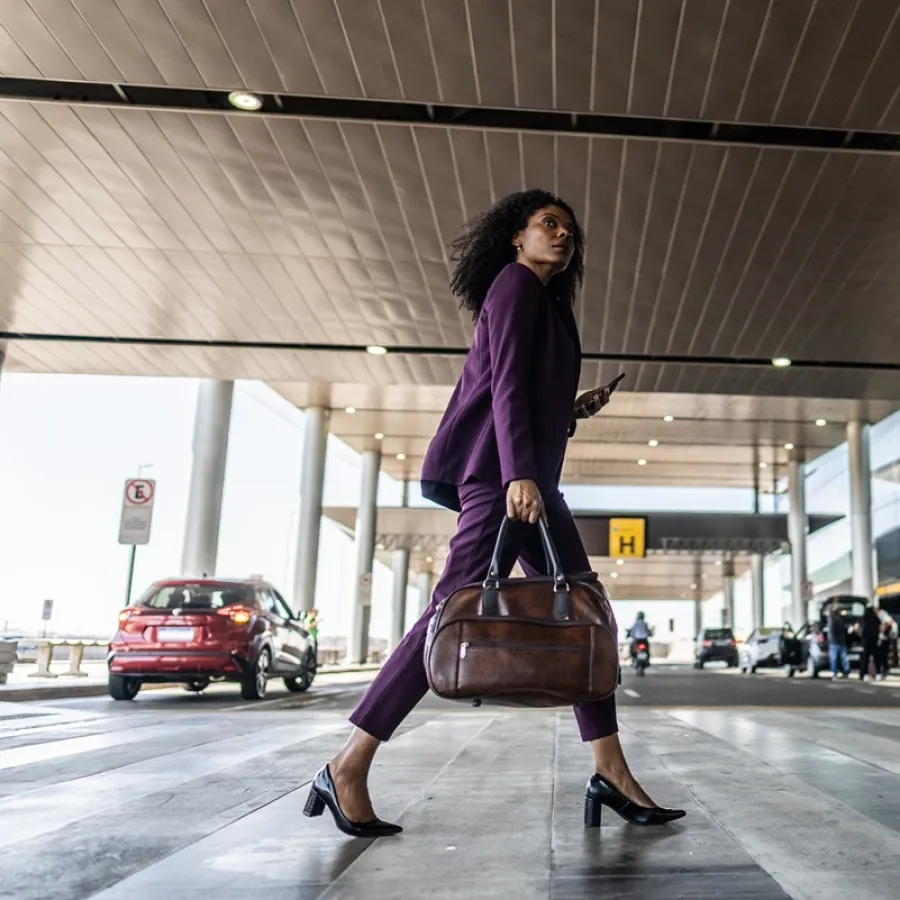 Lady with brown bag crossing road in airport